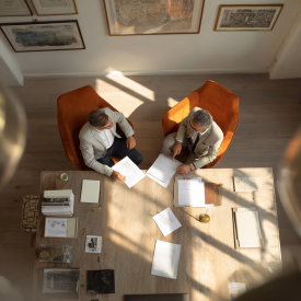 Podnikateľ vysvetľujúci klientovi riešenie cez tablet, ukazovanie grafických prvkov bez textu, bieli stredoeurópania, neutrálne web-friendly farby, bez t (2)